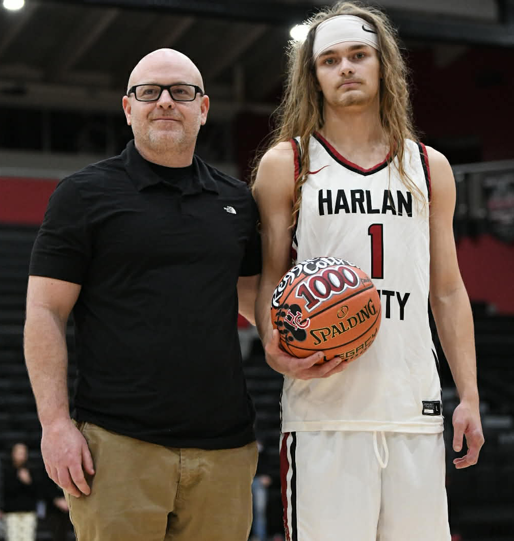 Harlan County senior Reggie Cottrell received a basketball from HCHS coach Kyle Jones in honor of surpassing the 1,000-point mark Friday in a win at Middlesboro. Cottrell is the last remaining starter from the Bears’ 2024 state runner-up squad.
