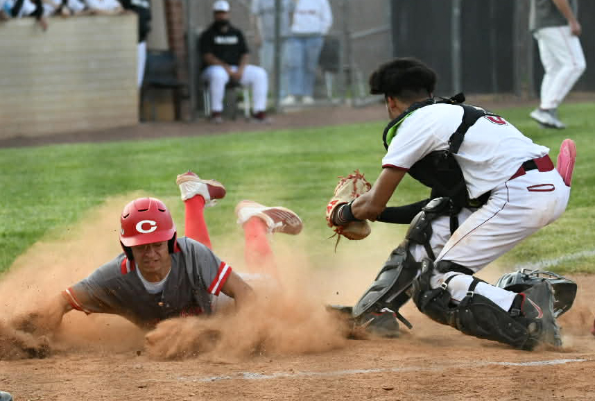 A Corbin player slid home with a run ahead of the tag from Harlan County catcher DaShaun Smith in Thursday's game. The visiting Redhounds won 17-2 in four innings.