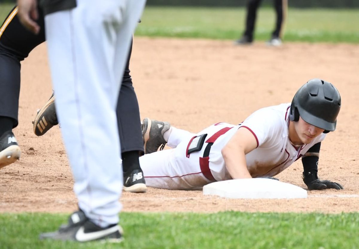 Harlan County's Gunner Burkhart went back to first base during Saturday's game against visiting Clay County. The Tigers won 8-5 in 10 innings.