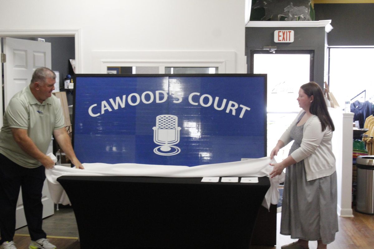 Tom Cawood and Bronwyn Haynes unveiled the section of “Cawood’s Court” that Cawood loaned to the Historic Harlan Museum during a ceremony Tuesday in downtown Harlan. Cawood is a cousin of Ledford, the legendary University of Kentucky broadcaster who was a native of Harlan County and voice of the Wildcats for 39 years.
